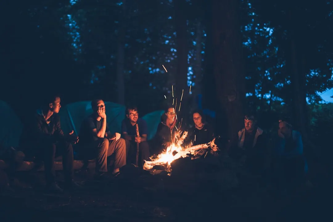 Menschen sitzen nachts um ein Lagerfeuer im Wald